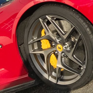 Réparation Jante Ferrari Jante en aluminium d'une voiture rouge avec étriers de frein jaunes.
